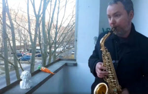 Der Ohrenblicker spielt Saxophon auf dem Balkon